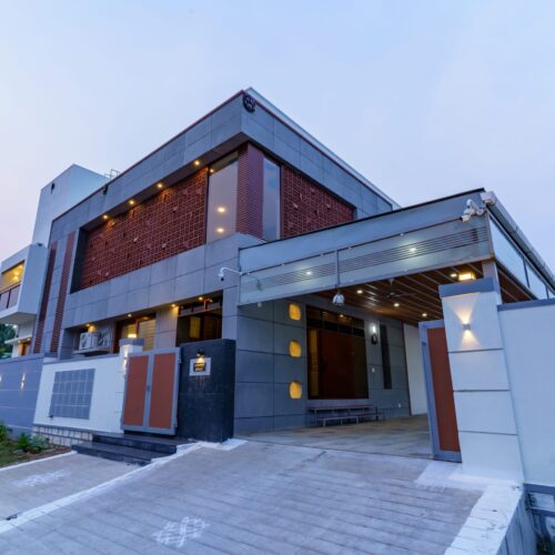 Modern facade of a 3BHK house in Salem featuring exposed concrete panels.